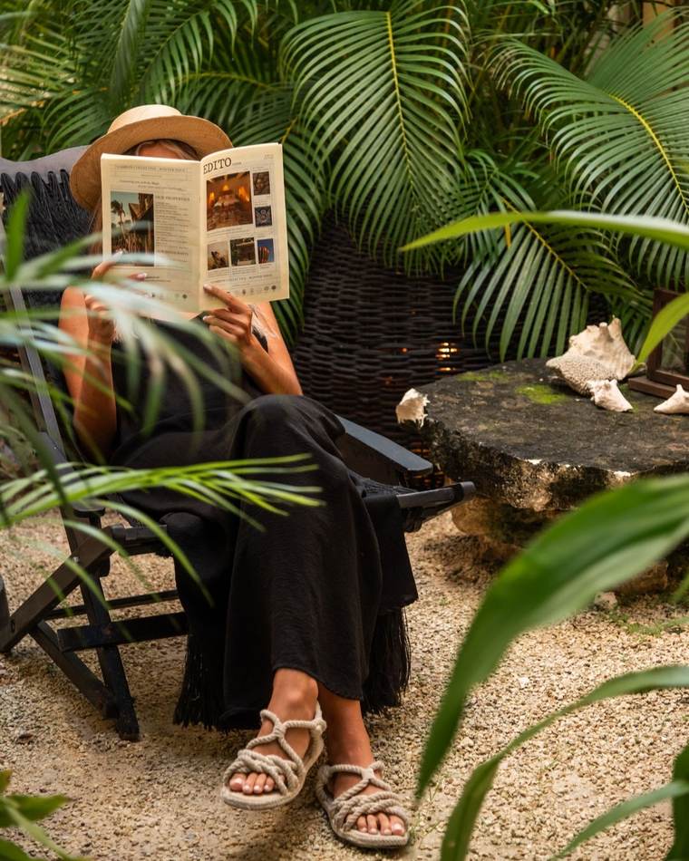 Mujer leyendo en un jardín tropical