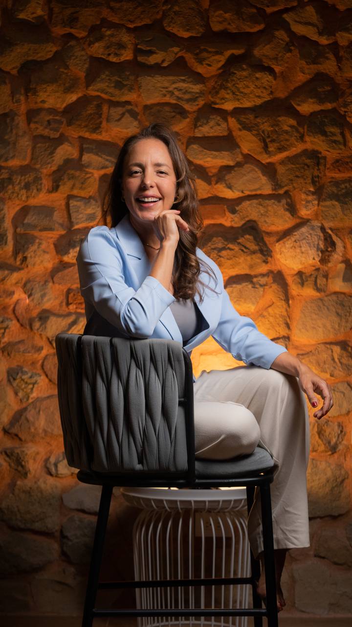 Retrato de Mauriett Quintero sentada frente a un muro de piedra