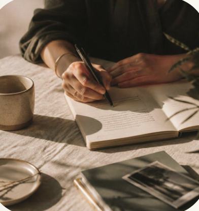 Manos escribiendo en un cuaderno durante una sesión de trabajo